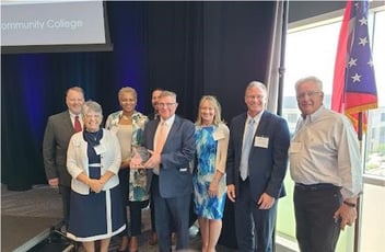 board of directors with award winner and award at Hocking College